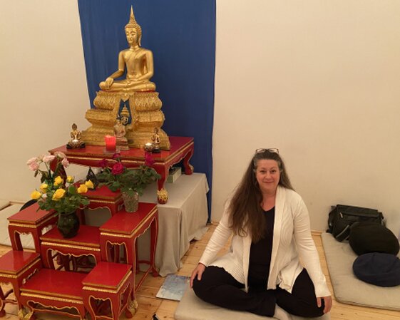 Michaela Berger neben dem Altar in der Theravada Schule Wien, Fleischmarkt